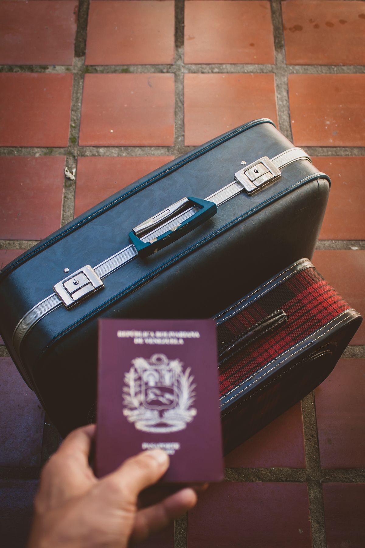 A traveler carrying a passport beside luggage